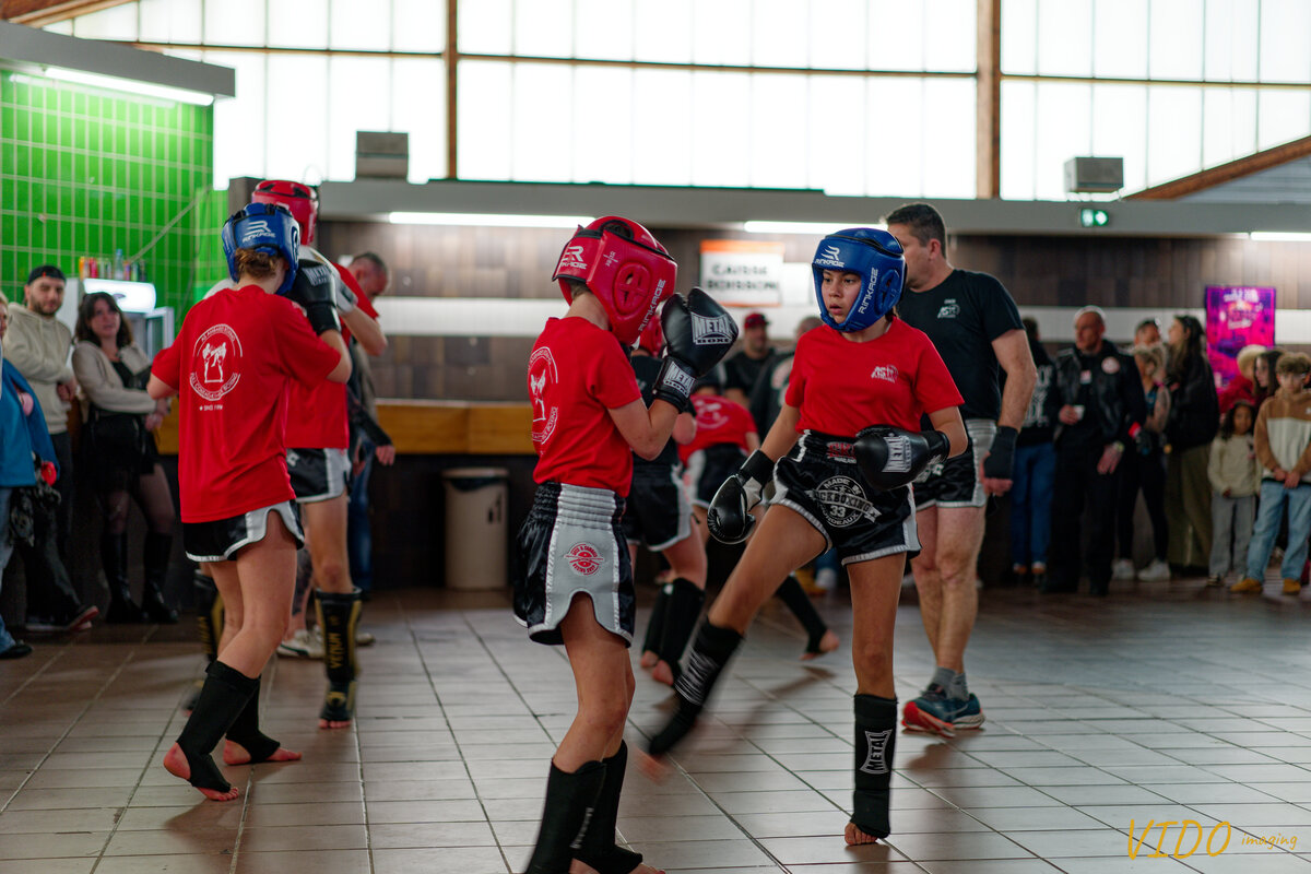 Jeunes pratiquants en démonstration de kick boxing, public en arrière-plan
